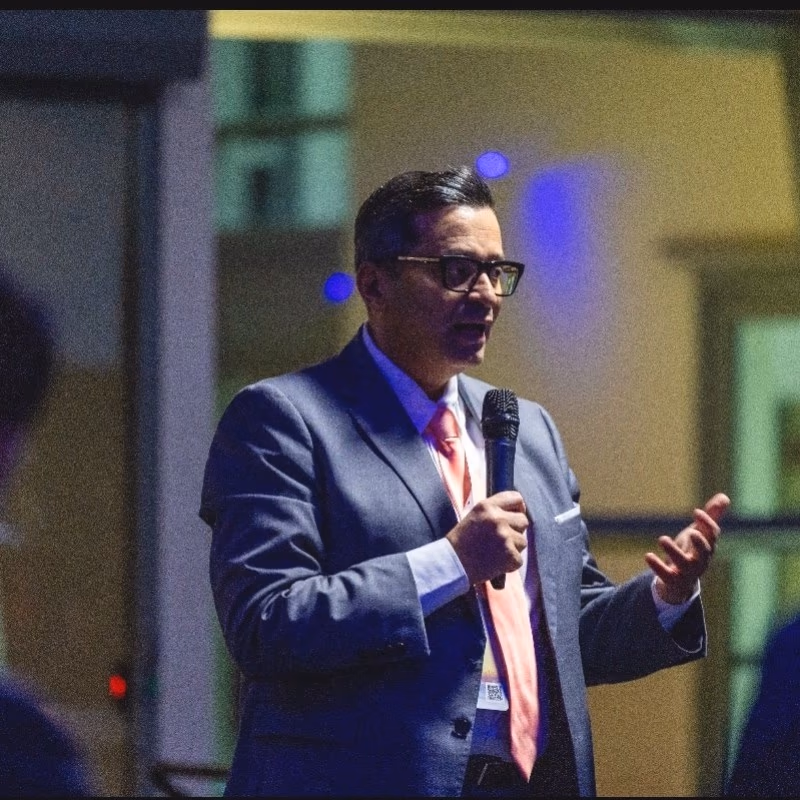 Jack Sarraj speaking into a microphone at an event