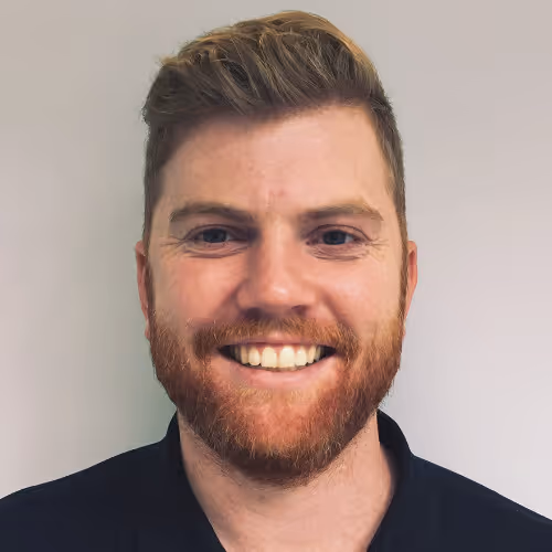 Headshot of Harry Balding smiling with a reddish beard